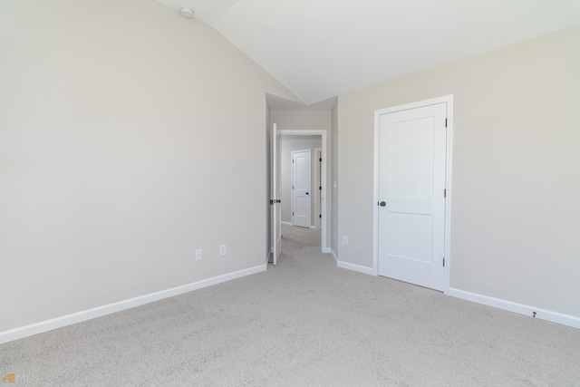 carpeted empty room featuring lofted ceiling