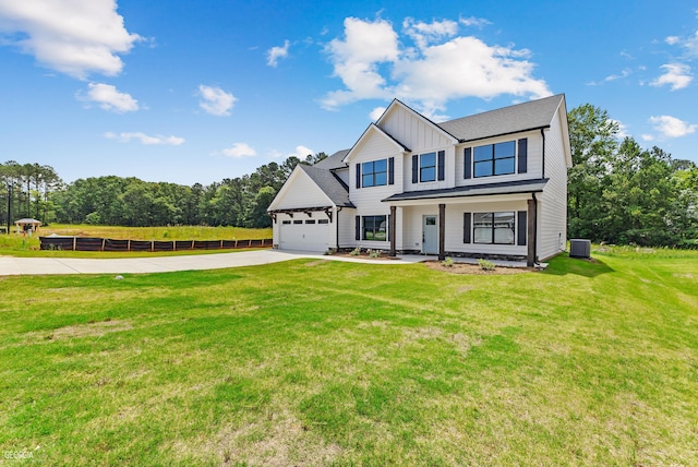 view of front of house featuring a garage, central air condition unit, and a front lawn