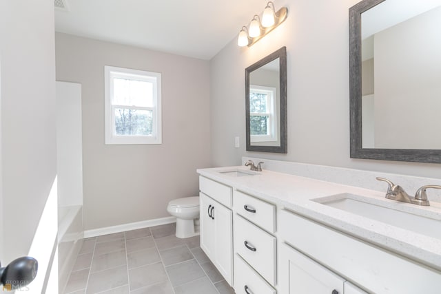 bathroom with vanity, tile patterned flooring, toilet, and a healthy amount of sunlight