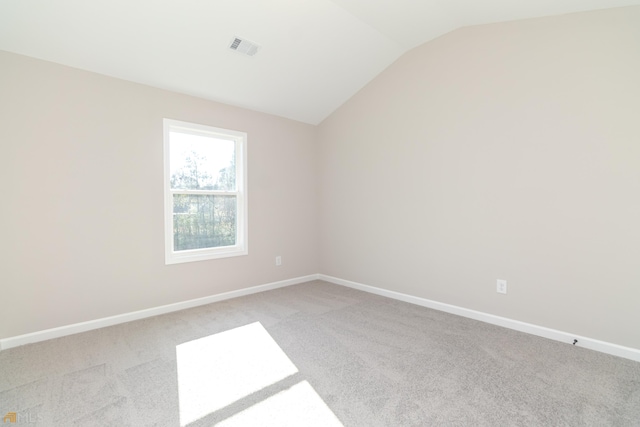 carpeted empty room featuring lofted ceiling