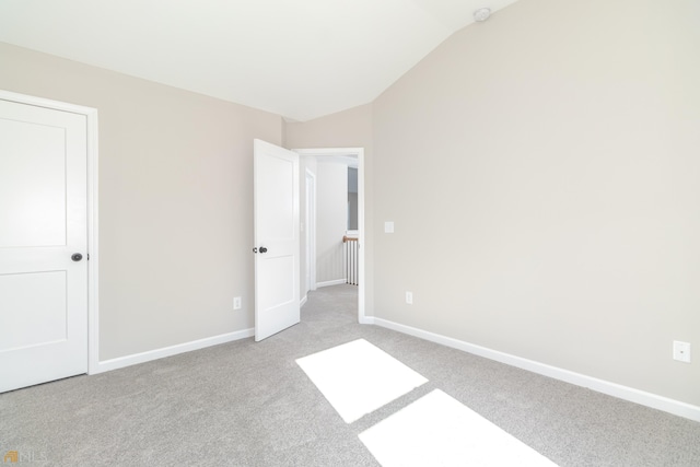 unfurnished bedroom with lofted ceiling and light carpet