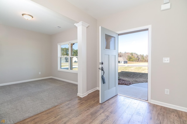 entrance foyer with light hardwood / wood-style floors and ornate columns