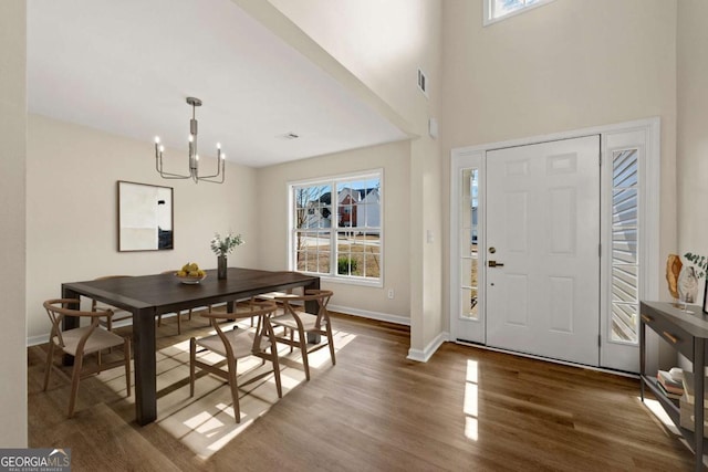 foyer entrance with a chandelier and dark hardwood / wood-style floors