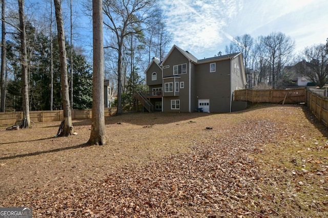 103 Ashwood Ct N, Stockbridge, GA 30281 - rear view of house with stairway, a fenced backyard, and a garage