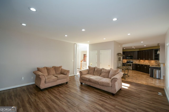 living room with dark hardwood / wood-style flooring and sink