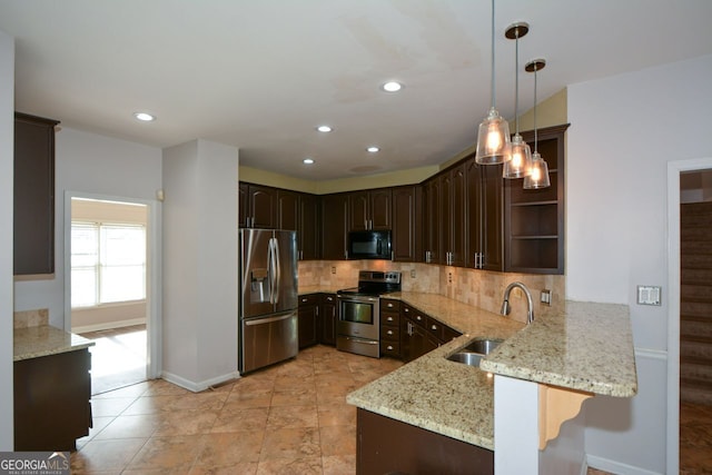 kitchen featuring sink, appliances with stainless steel finishes, hanging light fixtures, dark brown cabinetry, and kitchen peninsula