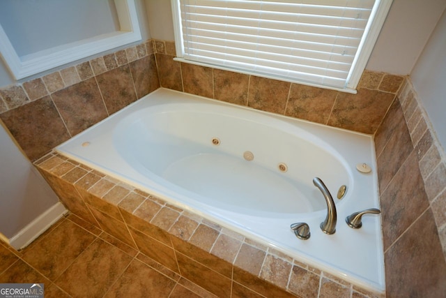 bathroom with tile patterned flooring and tiled bath