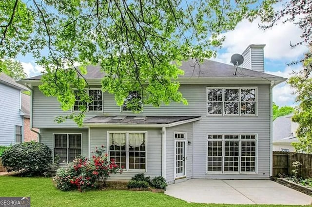 back of property featuring a patio area and a lawn