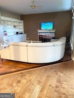 unfurnished living room with ceiling fan and hardwood / wood-style floors