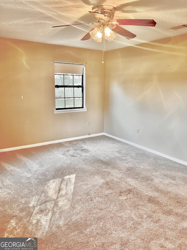 empty room with carpet floors and a textured ceiling