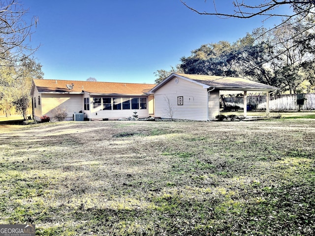 back of house featuring central AC, a yard, and a carport