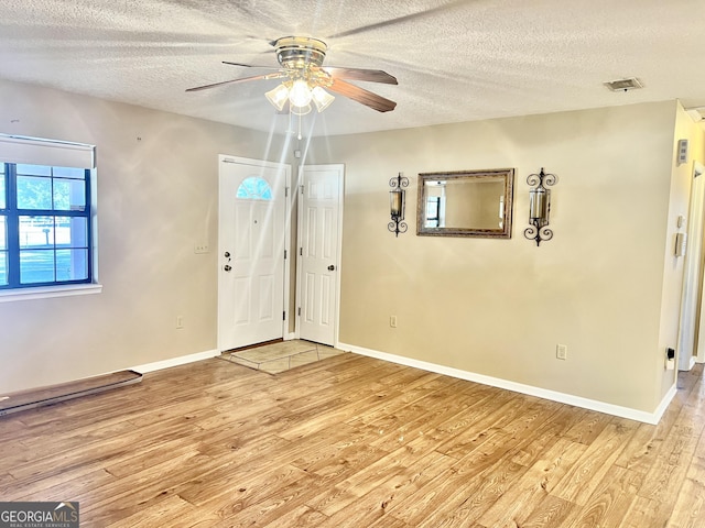 entrance foyer with light wood-type flooring, ceiling fan, and a textured ceiling