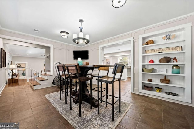 dining room with ornamental molding and a chandelier