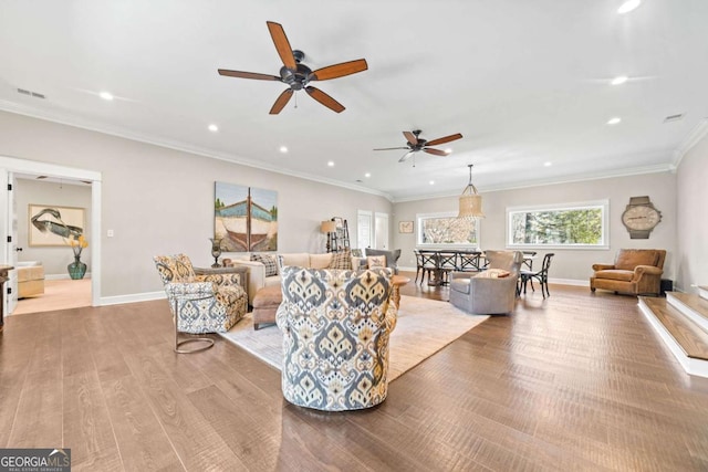 living room with ceiling fan, light wood-type flooring, and crown molding