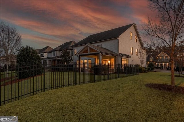 back house at dusk with a yard