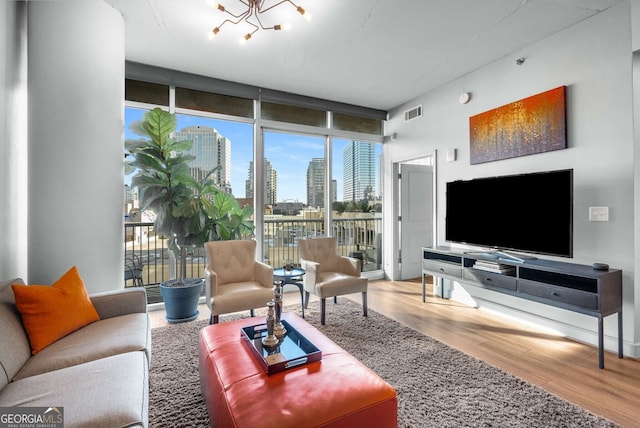 living room featuring an inviting chandelier, hardwood / wood-style floors, and expansive windows