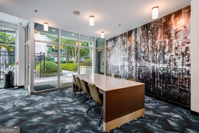 interior space with floor to ceiling windows and dark colored carpet