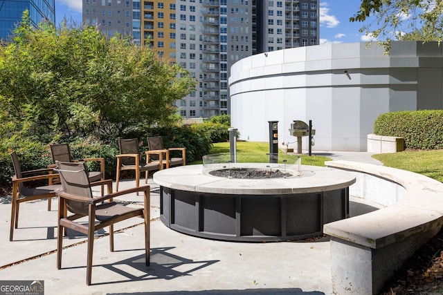 view of property's community featuring an outdoor fire pit and a patio