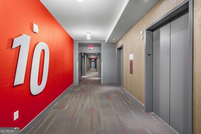 hall featuring elevator and dark carpet