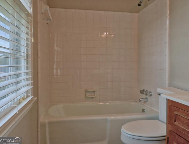 full bathroom with tiled shower / bath, vanity, and toilet