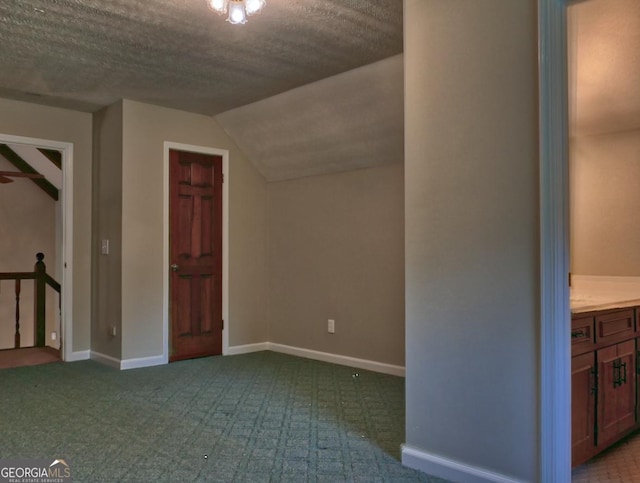 bonus room featuring lofted ceiling and a textured ceiling