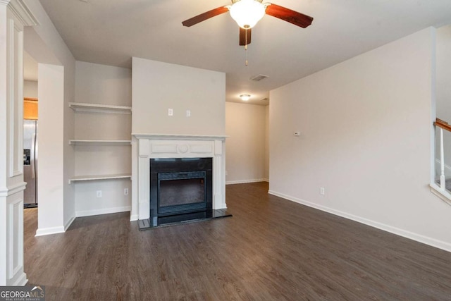 unfurnished living room featuring ceiling fan and dark hardwood / wood-style flooring