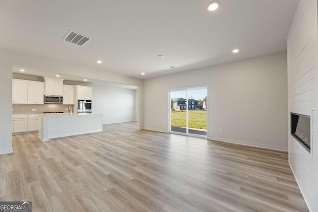 unfurnished living room with light hardwood / wood-style floors and a fireplace