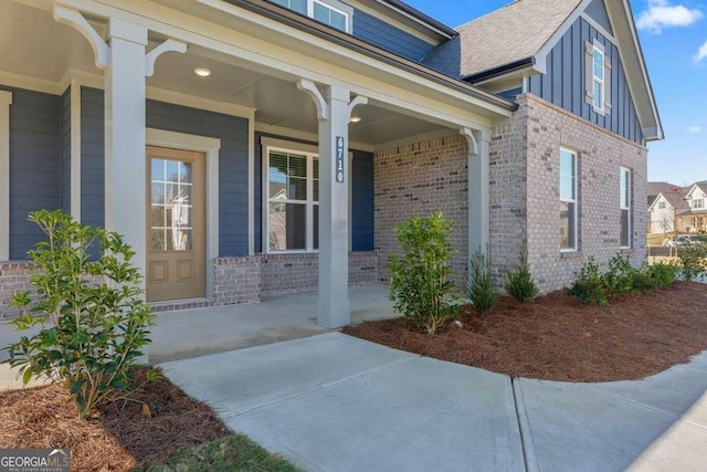 view of exterior entry featuring covered porch