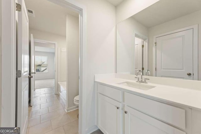 bathroom featuring toilet, vanity, and tile patterned floors