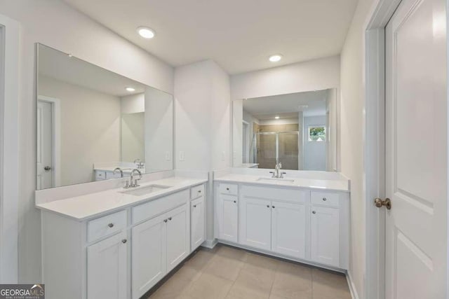 bathroom with tile patterned flooring, a shower with door, and vanity