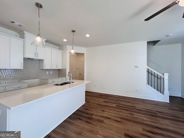 kitchen with dark hardwood / wood-style flooring, sink, white cabinetry, decorative light fixtures, and tasteful backsplash