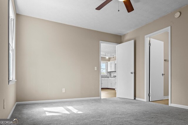 carpeted empty room with ceiling fan