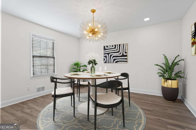 dining space featuring an inviting chandelier and dark hardwood / wood-style flooring