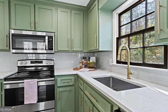 kitchen featuring appliances with stainless steel finishes, green cabinetry, a healthy amount of sunlight, and sink