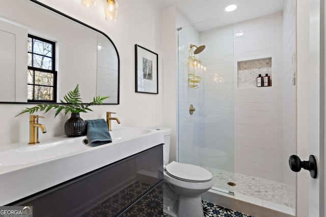 bathroom featuring toilet, tile patterned flooring, vanity, and tiled shower