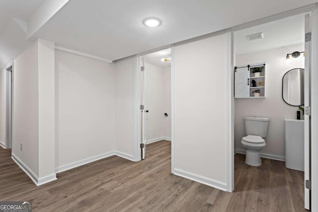 interior space featuring hardwood / wood-style floors and toilet