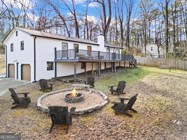 exterior space with an outdoor fire pit, a garage, and a wooden deck