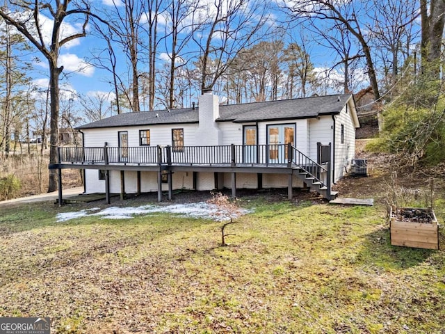 rear view of house featuring a yard and a wooden deck