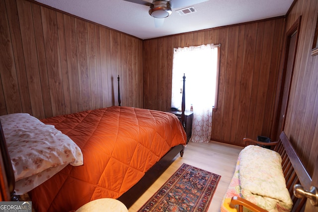 bedroom with ceiling fan and wooden walls