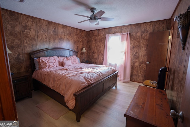 bedroom featuring a textured ceiling, ceiling fan, and light hardwood / wood-style floors