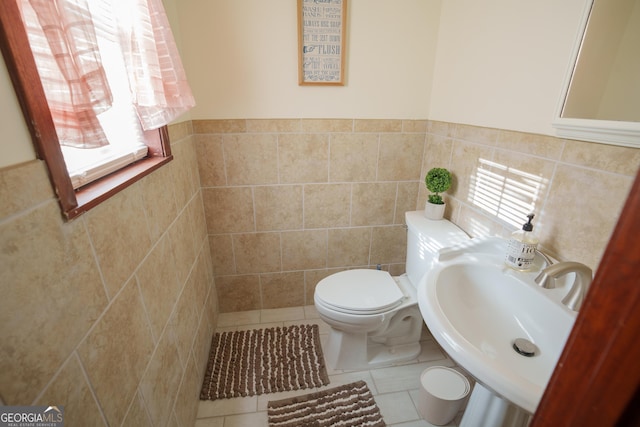 bathroom featuring tile walls, toilet, tile patterned floors, and sink