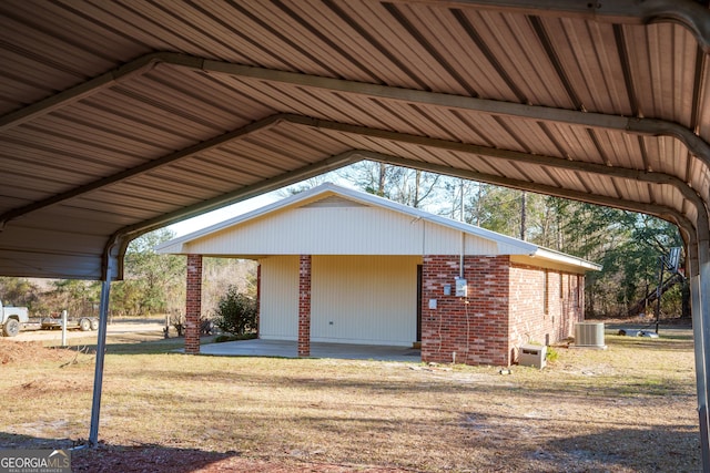 garage with a lawn, central AC, and a carport