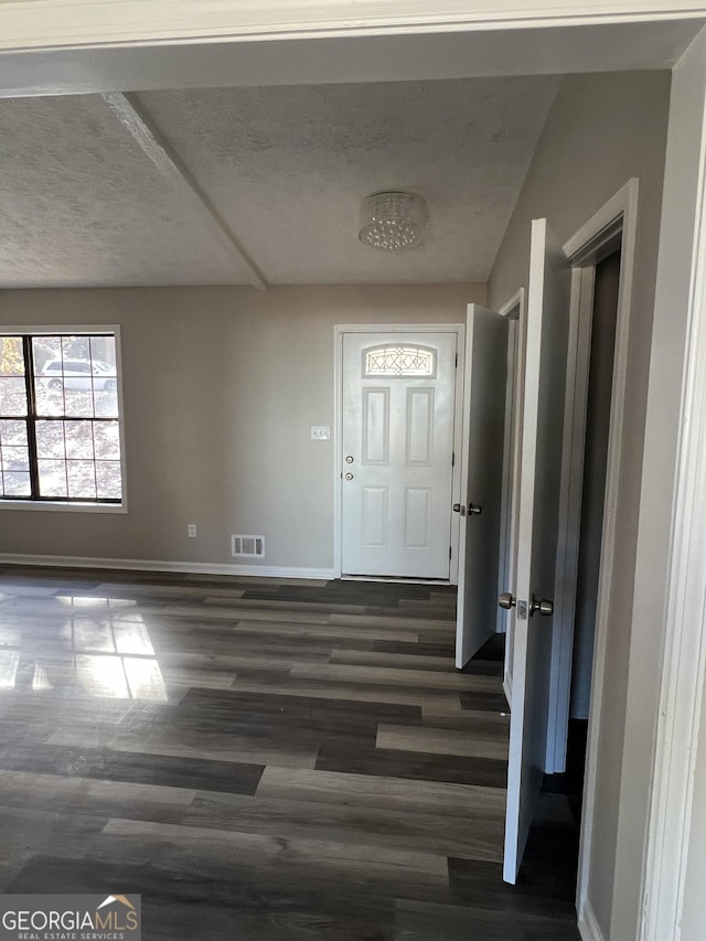 entrance foyer featuring a textured ceiling and dark hardwood / wood-style floors