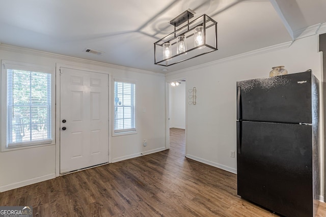 foyer featuring hardwood / wood-style floors, ornamental molding, and a healthy amount of sunlight