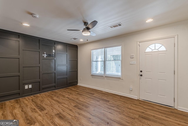 entrance foyer with hardwood / wood-style flooring, ceiling fan, and crown molding