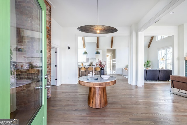 interior space with lofted ceiling with beams and dark hardwood / wood-style flooring