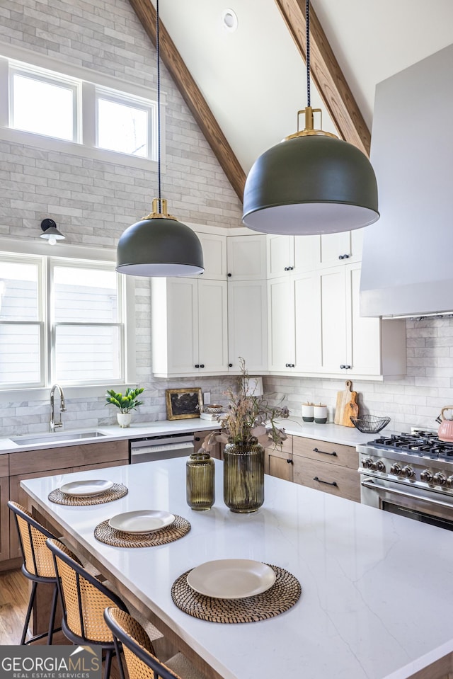 kitchen featuring custom exhaust hood, tasteful backsplash, decorative light fixtures, white cabinets, and sink