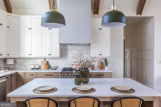 kitchen with decorative light fixtures, white cabinets, beam ceiling, and a center island