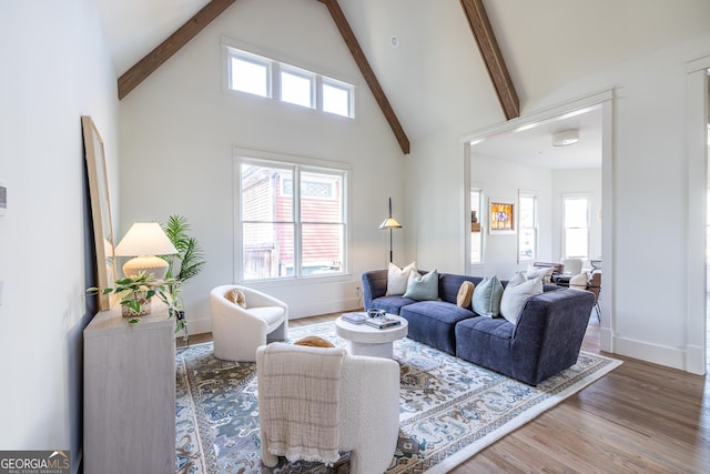 living room with beamed ceiling, wood-type flooring, and high vaulted ceiling