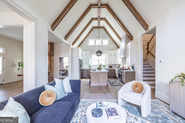 living room with beam ceiling, high vaulted ceiling, and light hardwood / wood-style floors